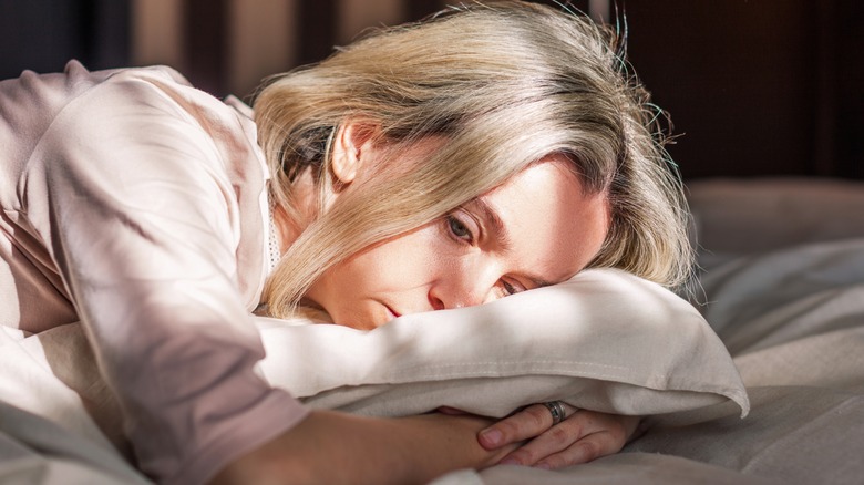 Depressed woman lying in bed