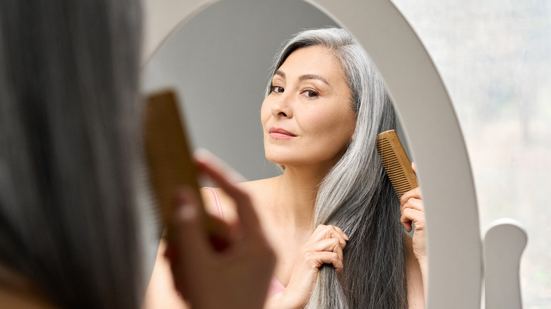 A woman combs her hair 