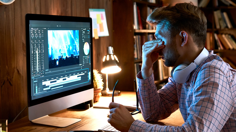 Man rubs his eyes while at a computer