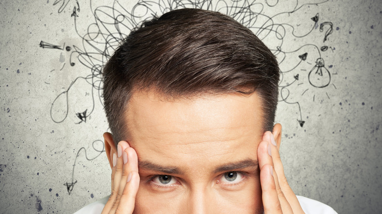 man holding his temples suffering from ADHD