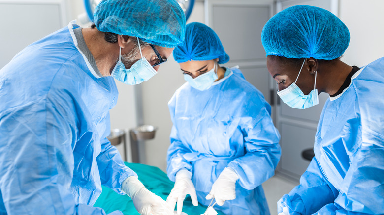 3 masked surgeons in surgery