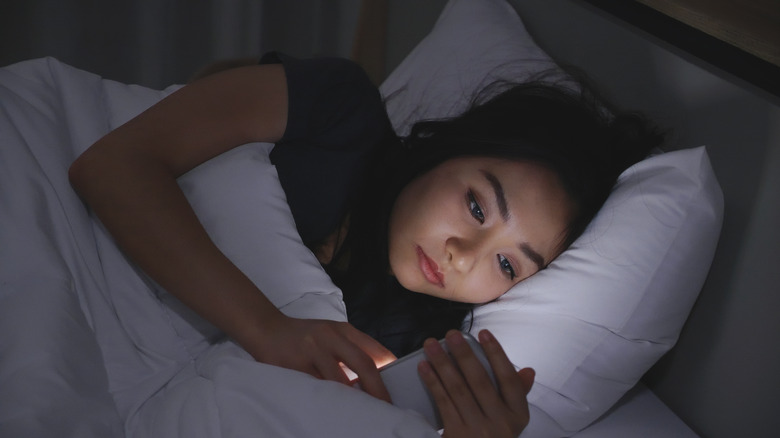 women with phone in bed