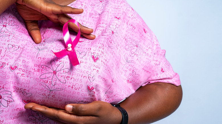 black women with breast cancer ribbon on chest