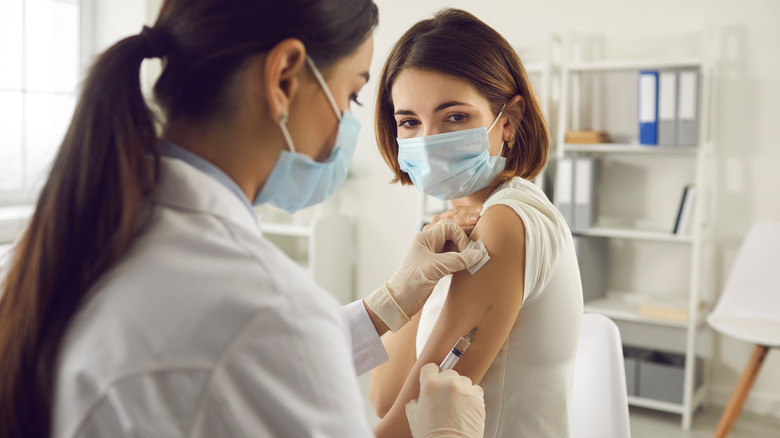 Female doctor gives female patient a vaccination