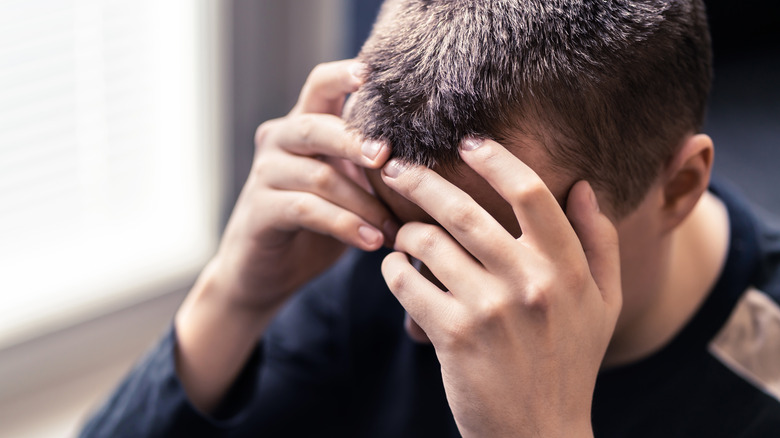 Depressed man with head in hands