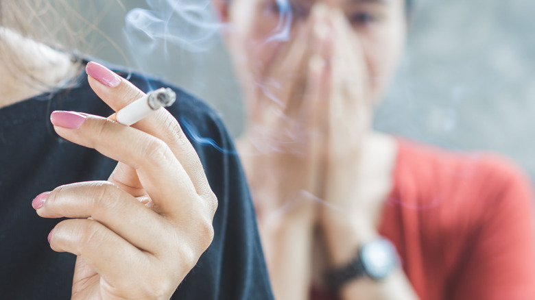 A woman smokes a cigarette