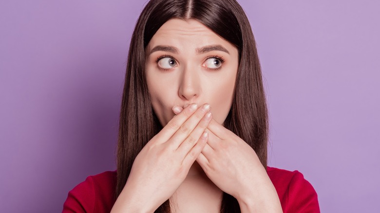 woman covering mouth with hands