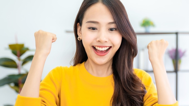 smiling young woman fist pumping