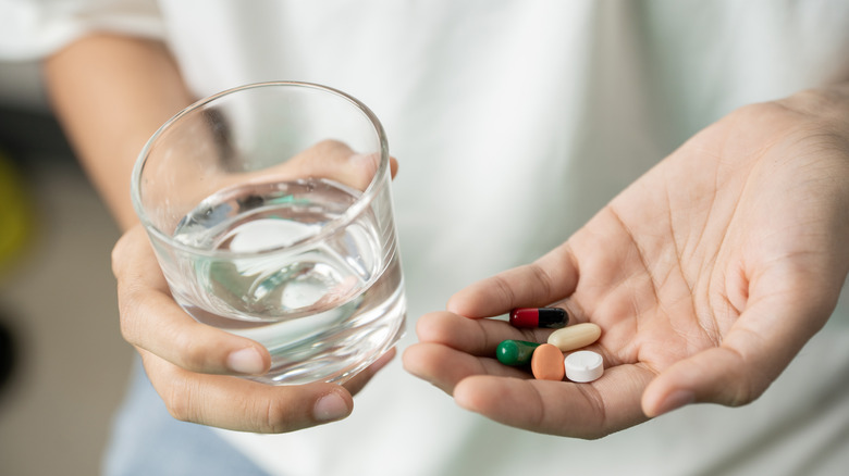 Person holding water and medication