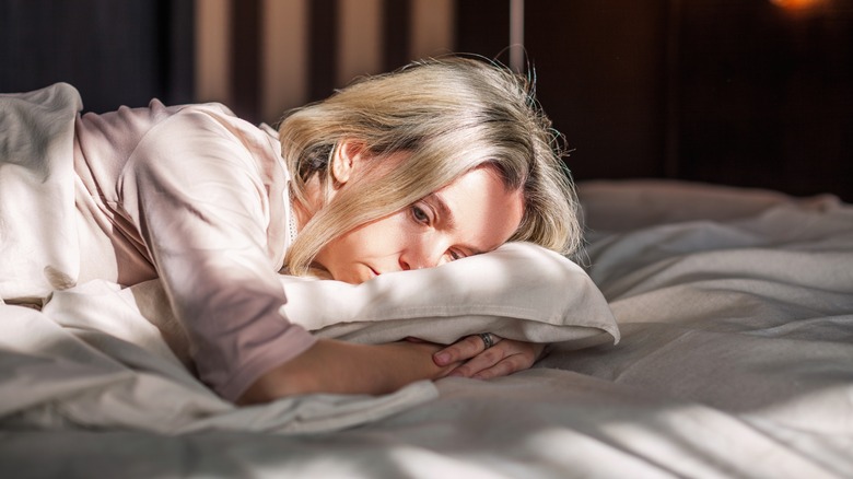 A woman is lying in bed in pain