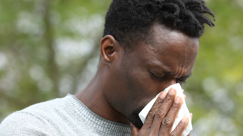 man blowing nose