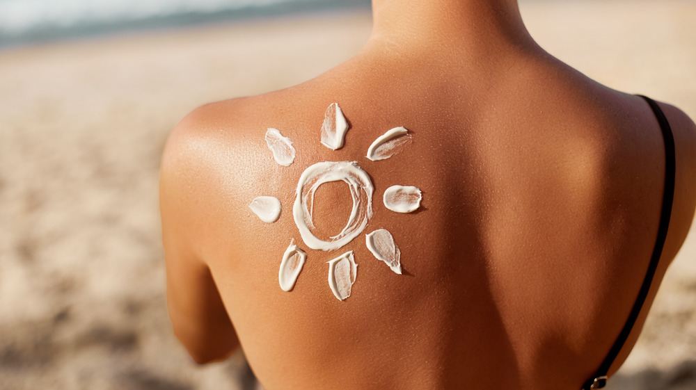 woman with sunblock on her back
