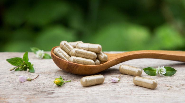 herbal supplements on wooden spoon