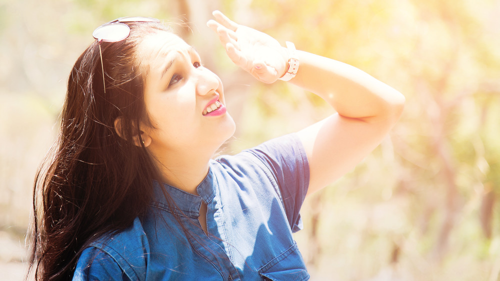 woman shielding eyes from sun