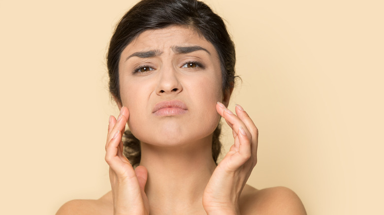 worried woman touching skin