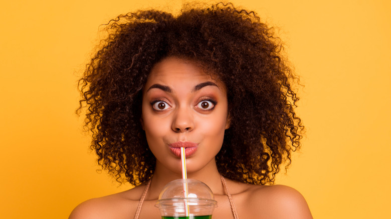 Woman drinking through straw