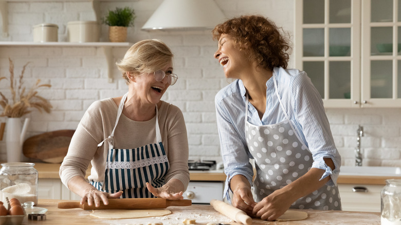 women laughing while baking in a kitchen