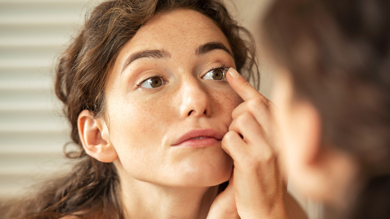 woman putting in contacts