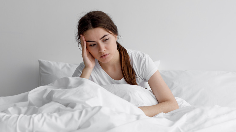 an unhappy woman in bed