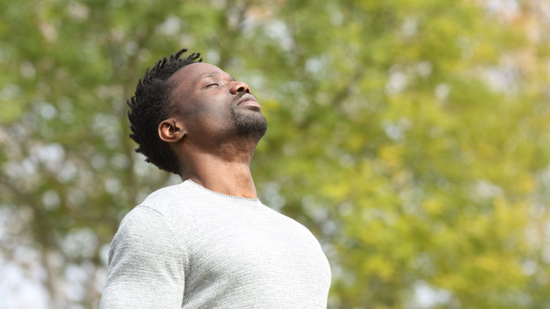 Man breathing deeply in a park 