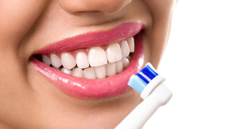 Close-up of woman using an electric toothbrush