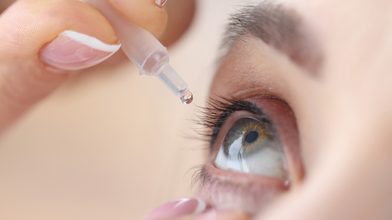 Woman applying eye drops