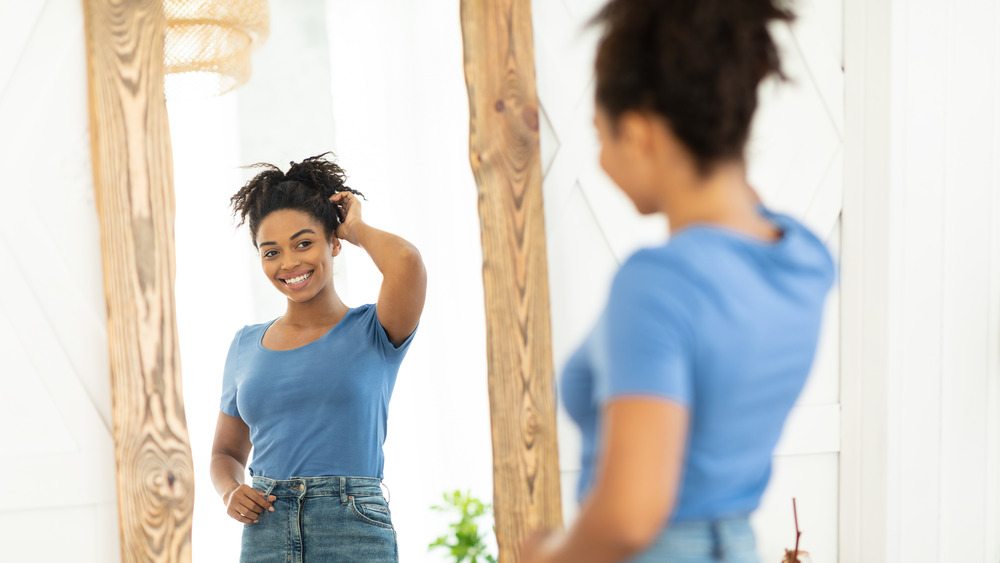 Black woman admiring herself in mirror
