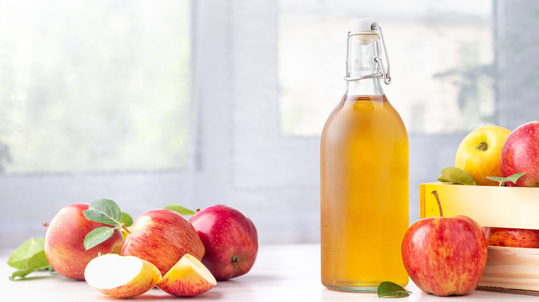 bottle of ACV on table with apples