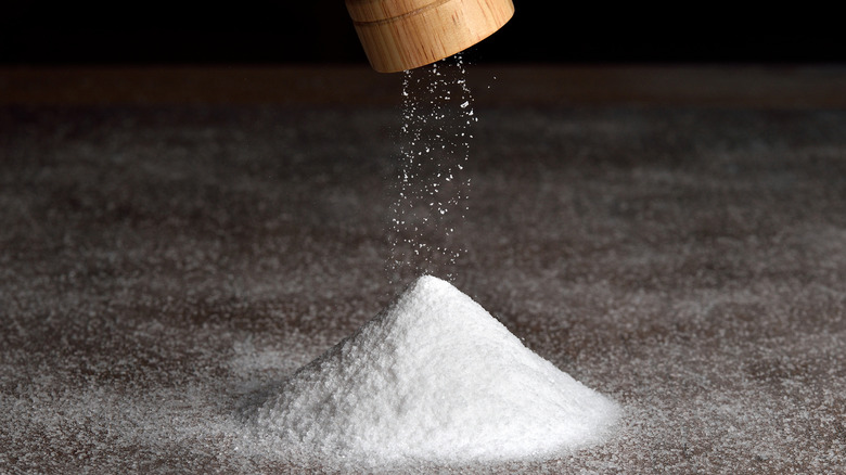 a mound of salt coming from a  salt shaker 
