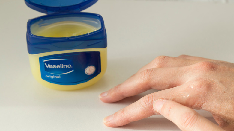 A woman uses Vaseline on her hands