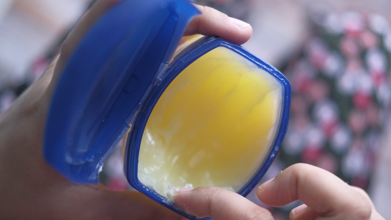 Closeup of a person applying Vaseline (petroleum jelly).