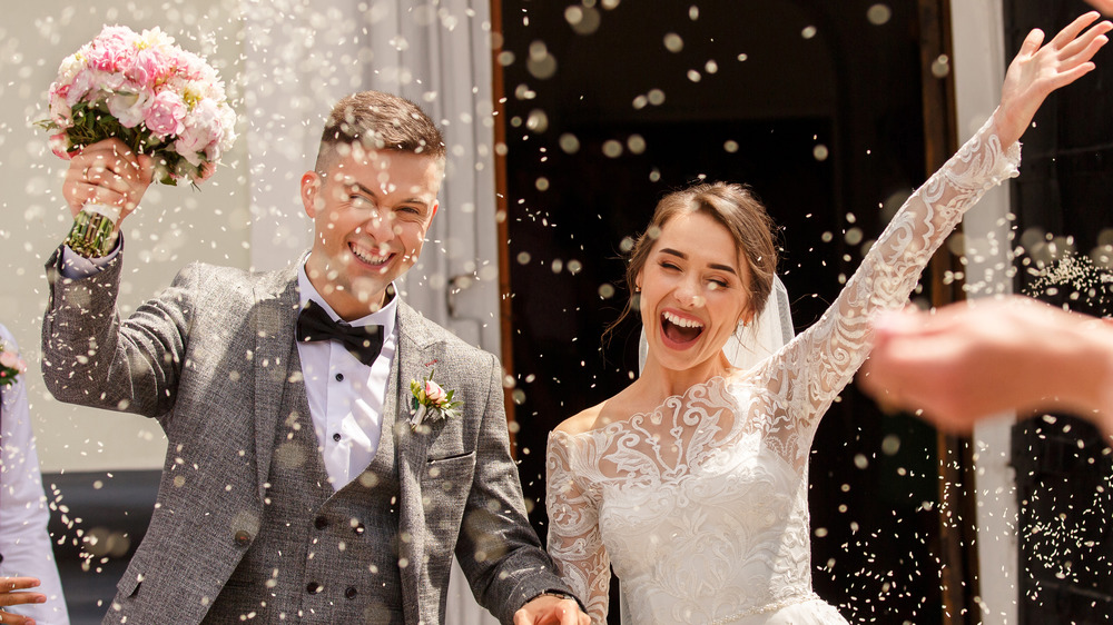 Happy Bride & Groom Amidst Rice