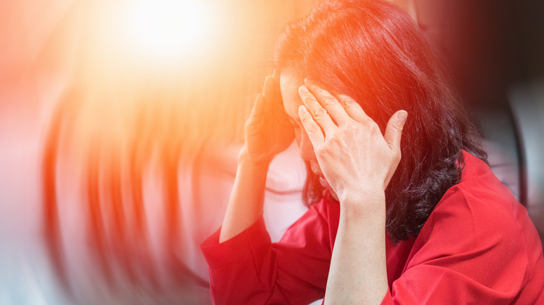 woman holding head in pain