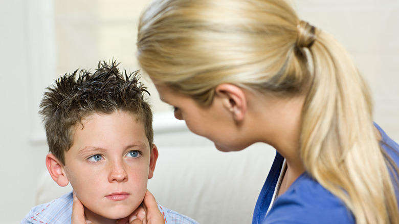 Child being examined for mumps by doctor