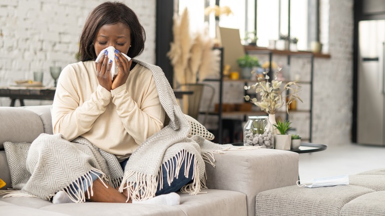 Woman wiping nose with tissue