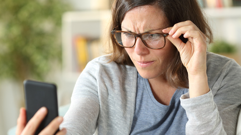 woman having trouble reading from phone