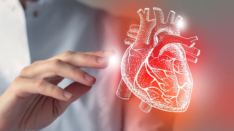 A doctor reaches out to touch a virtual image of a human heart