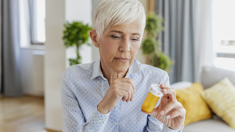 woman looking at her bottle of medication