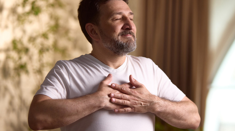 man enjoying being awake and happy in bedroom