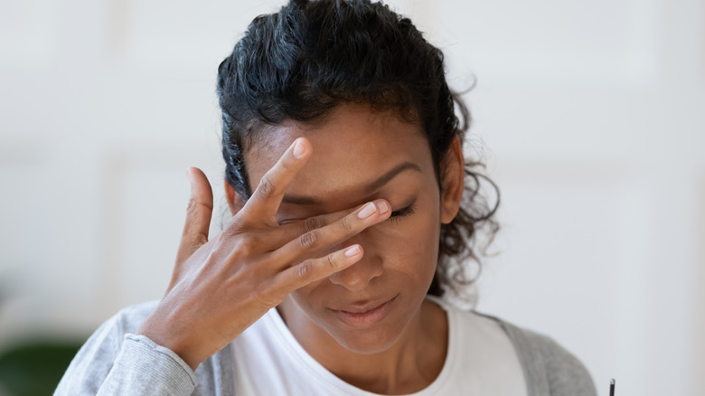 A woman rubbing her eyes.