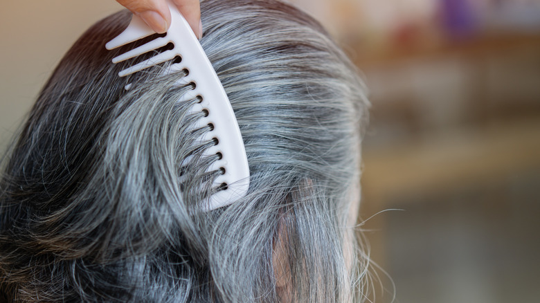 woman running comb through gray hair