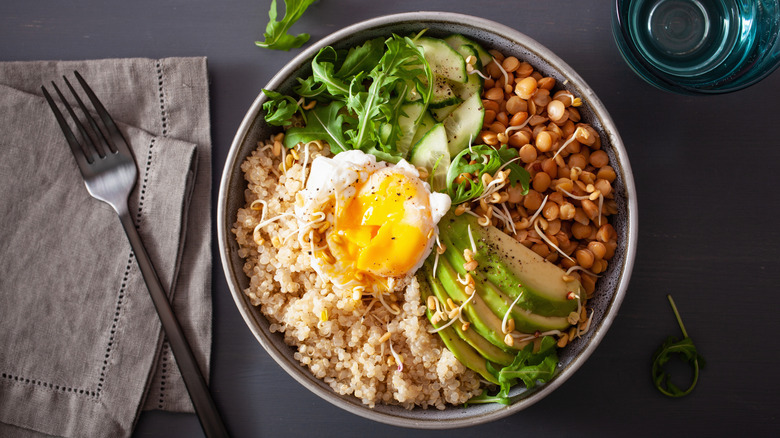 Breakfast bowl with egg, quinoa, lentils, and avocado