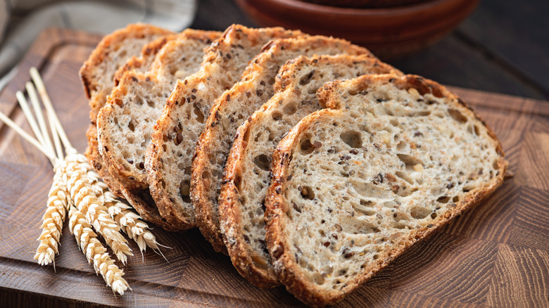 Whole wheat sourdough bread sliced on a wooden cutting board