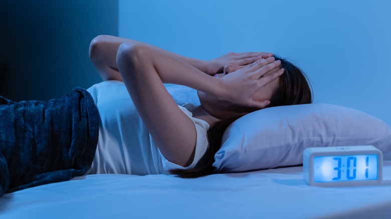 Stressed out woman lying in bed