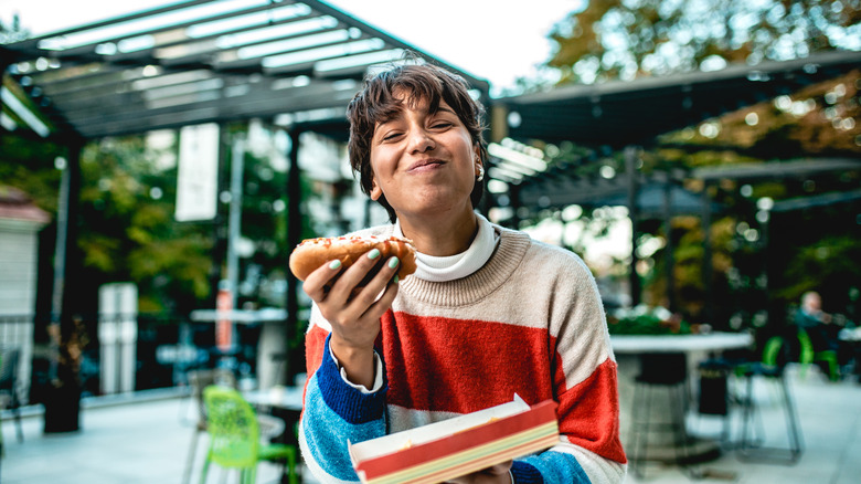 Woman eating hot dog outdoors