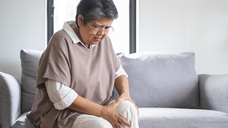 Woman gripping her leg in discomfort