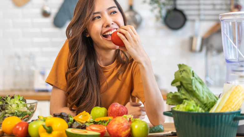 A woman in her kitchen eating healthy foods