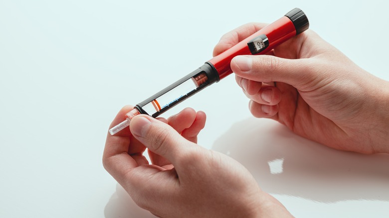 hands holding insulin pen