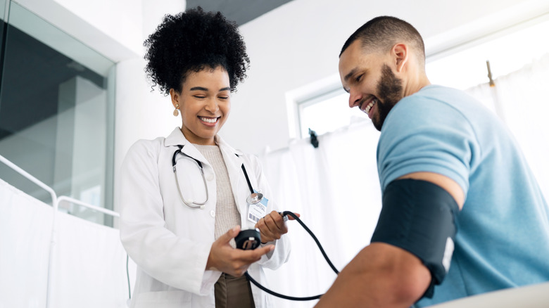 A health professional checking a man's blood pressure