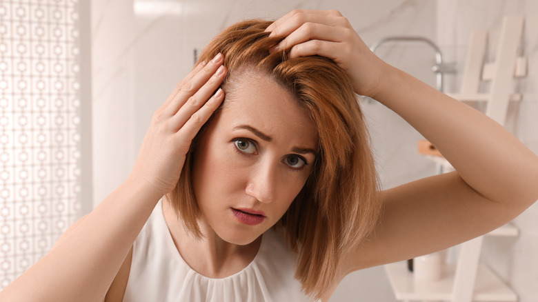 Woman checking thinning hair